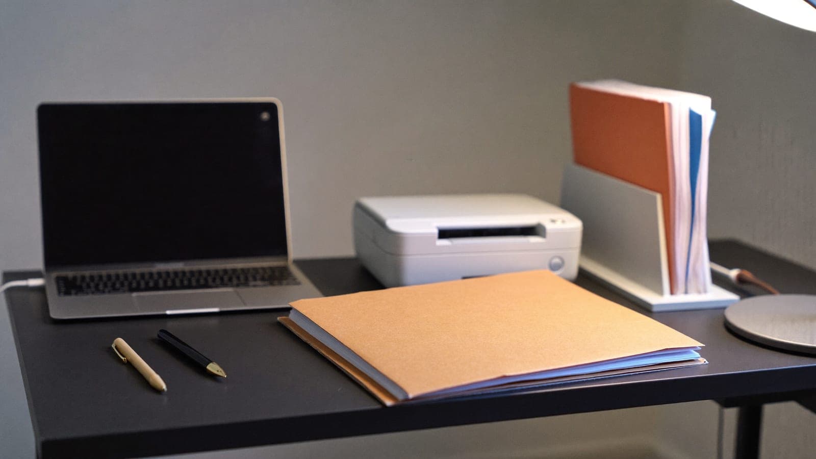A professional services manager reviewing invoice documents beside a laptop and organized folders, with subtle workflow lines connecting invoicing, storage, and email
